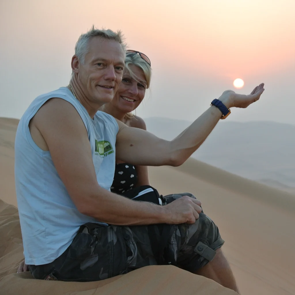 A couple sit on a dune